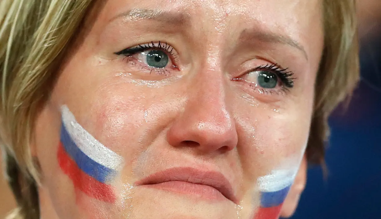 Seorang suporter Rusia menangis setelah tim kesayangannya kalah dari Kroasia pada laga perempat final Piala Dunia 2018 di Stadion Olimpiade Fisht, Sabtu (7/7). Tuan rumah Rusia tumbang lewat adu penalti melawan Kroasia 3-4. (AP/Darko Bandic)