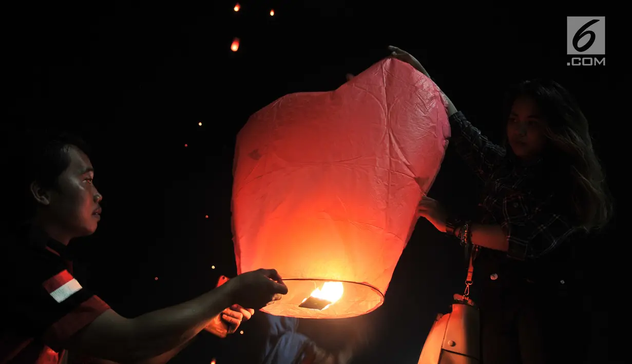 Pengunjung menerbangkan lampion saat perayaan Tahun Baru Imlek di Pantai Lagoon, Ancol, Jakarta, Selasa (5/2) malam. Sebanyak 500 lampion diterbangkan oleh pengunjung dalam  rangka menutup Festival Imlek di Ancol. (Merdeka.com/Iqbal S Nugroho)