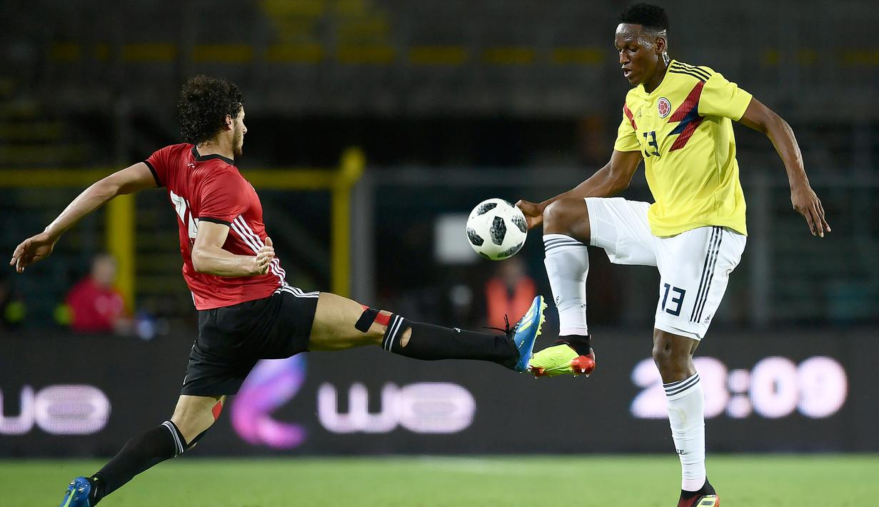 Pemain Mesir, Ramadan Sobhi (kiri) berusaha menutup pergerakan pemain Kolombia, Yerry Mina pada laga uji coba di "Atleti Azzurri d'Italia Stadium”, Bergamo, (1/6/2018). Mesir dan Kolombia bermain imbang 0-0. (AFP/Marco Bertorello)