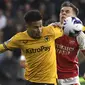 Gelandang Wolverhampton Wanderers, Joao Gomes (kiri) berebut bola dengan gelandang Arsenal, Leandro Trossard pada laga pekan ke-33 Premier League 2023/2024 di Molineux Stadium, Wolverhampton, Sabtu (20/4/2024). (AP Photo/Rui Vieira)