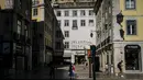 Orang-orang menunggu untuk menyeberang jalan di Rossio Square di Lisbon (14/7/2021). Hampir setengah dari populasi Portugal diberlakukan jam malam lagi awal bulan ini. (AFP/Patricia De Melo Moreira)