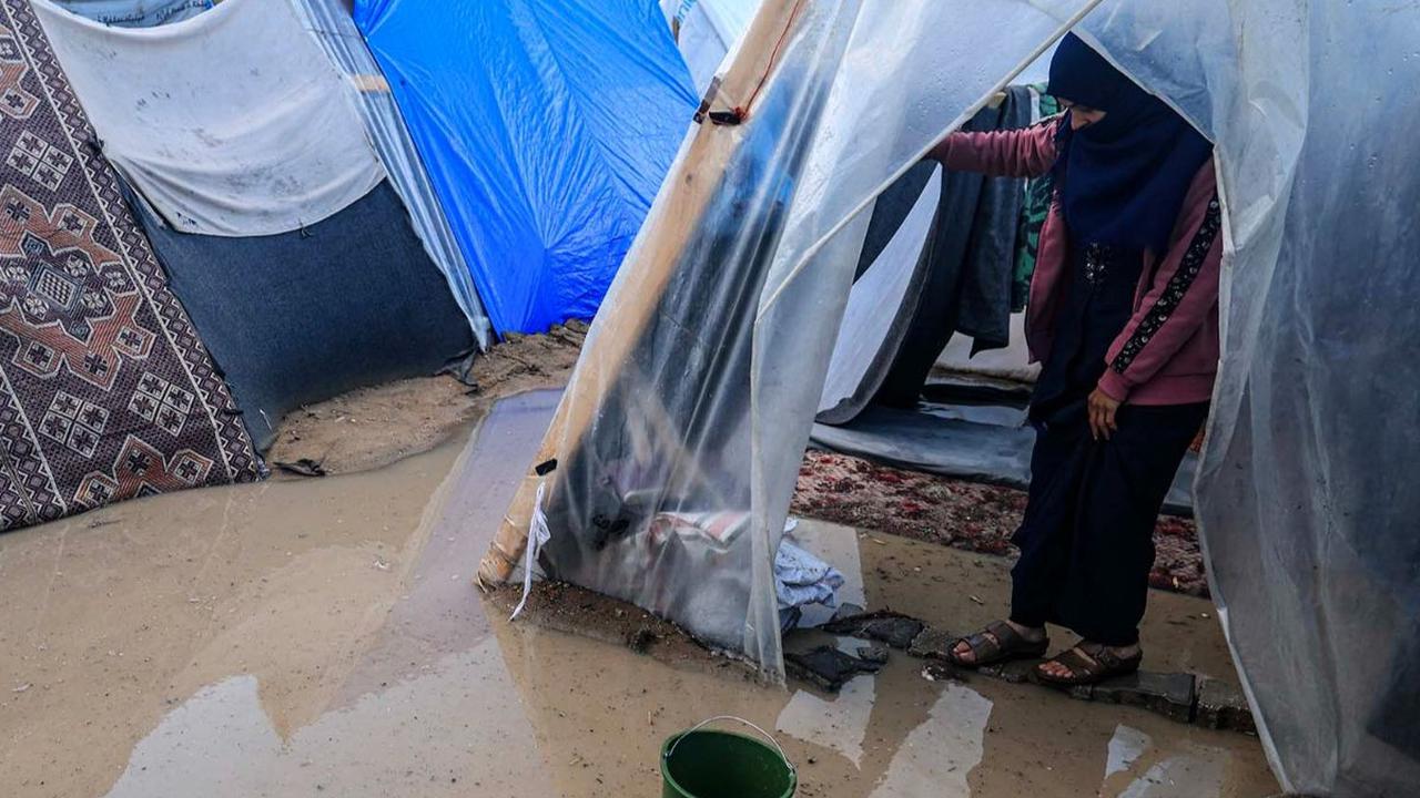 Guyuran hujan lebat menambah penderitaan warga Palestina yang mengungsi di Rafah, Jalur Gaza selatan, pada Sabtu (27/1/2024). Pasalnya, kamp pengungsian warga Palestina yang melarikan diri dari serangan Israel itu tampak terkepung genangan banjir.