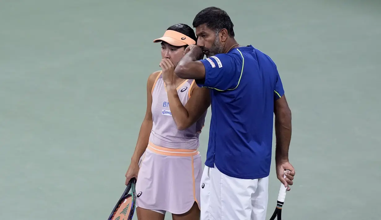 Petenis Indonesia, Aldila Sutjiadi (kanan) berbincang dengan petenis India, Rohan Bopanna saat bertanding melawan petenis ganda campuran Amerika Serikat, Taylor Townsend/Donald Young pada laga semifinal US Open 2024 yang berlangsung di di Stadion Louis Amstrong, New York, Amerika Serikat, Rabu (04/09/2024) WIB. (AP Photo/Eduardo Munoz Alvarez)
