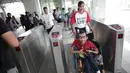 Petugas membantu penyandang disabilitas melintasi "Gate Elektronik" di Stasiun LRT Veldrome, Jakarta, Sabtu (27/4). Kegiatan yang diikuti Jakarta Barrier Free Tourism (JBFT) tersebut untuk mengenalkan kereta Lintas Rel Terpadu (LRT)  lebih dekat kepada masyarakat. (Liputan6.com/Faizal Fanani)