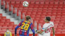 Bek Barcelona, Oscar Mingueza berebut bola udara dengan bek Sevilla, Diego Carlos pada pertandingan leg pertama semifinal Copa del Rey di stadion Ramon Sanchez Pizjuan di Seville, Spanyol, Kamis (10/2/2021).  Sevilla menang atas Barcelona 2-0. (AP Photo/Angel Fernandez)