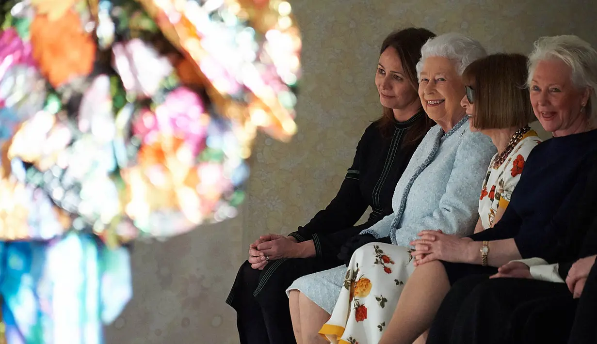 Ratu Elizabeth II duduk di sebelah Ratu Fashion, Anna Wintour menyaksikan pagelaran London Fashion Week 2018, Selasa (20/2). Kunjungan pertama Ratu Elizabeth di pekan mode tersebut dilakukan mendukung industri fashion negaranya (Yui Mok/Pool photo via AP)