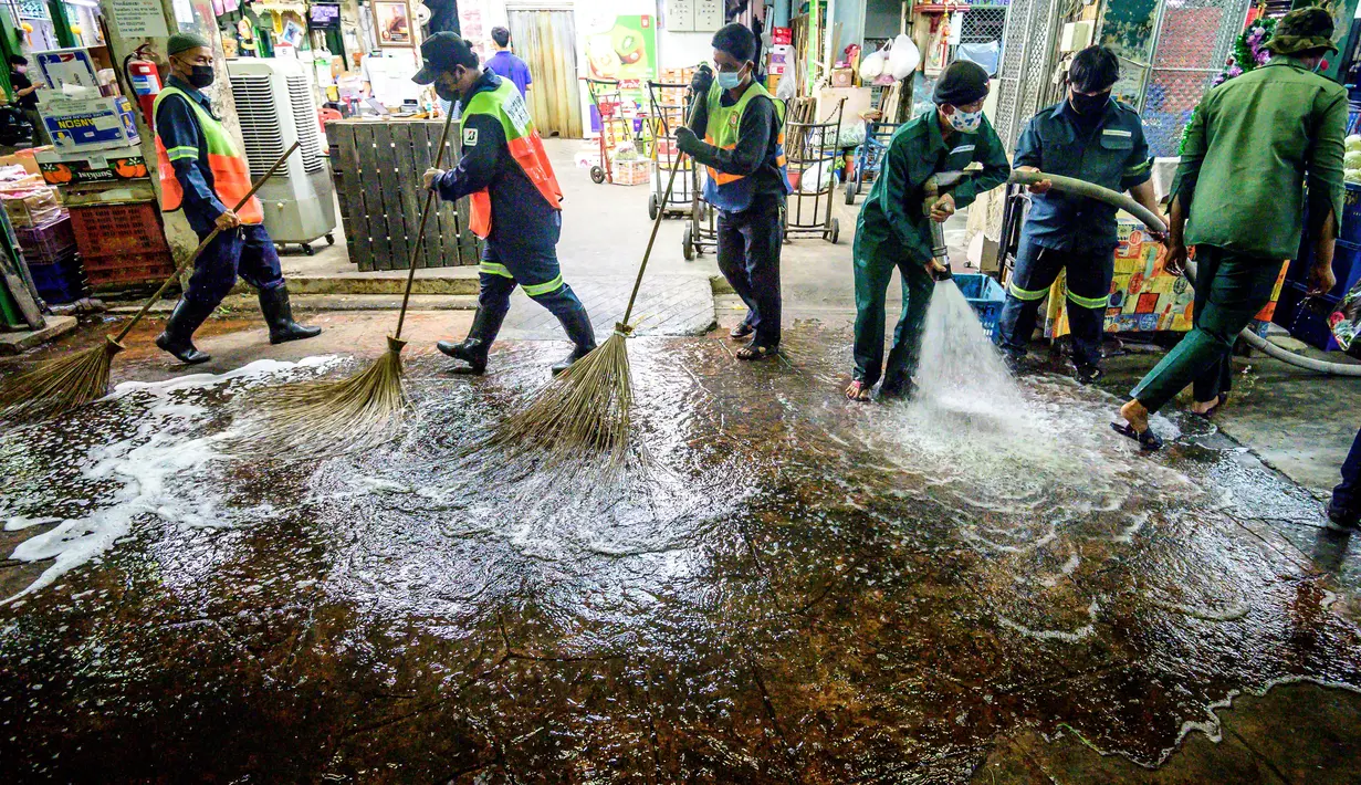 Pekerja Otoritas Metropolitan Bangkok menyapu membersihkan dan mendisinfeksi Pasar Bunga Yodpiman di Bangkok (6/1/2021). Pemerintah memberlakukan pembatasan lebih lanjut karena wabah virus Corona Covid-19 baru-baru ini. (AFP/Mladen Antonov)