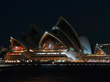 Gedung Opera Sydney terlihat dengan lampu dimatikan selama Earth Hour di Sydney (27/3/2021). (AFP/Steven Saphore)