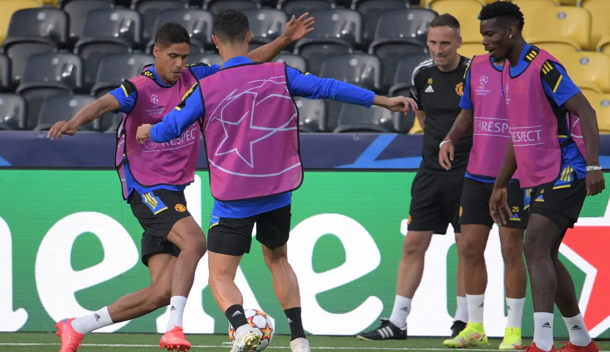Bek Manchester United, Raphael Varane (kiri) bersama penyerang  Christiano Ronaldo (kedua dari kiri) dan gelandang Paul Pogba (kanan) ambil bagian dalam sesi latihan di Bern (13/9/2021). Manchester United akan bertanding melawan Young Boys pada Grup F Liga Champions. (AFP/Sebastien Bozon)