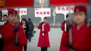 Sejumlah wanita memegang papan pengarahan saat menyambut peserta Kongres Rakyat Nasional di Beijing, China, Senin (4/3). Kongres ini dihadiri ribuan delegasi dari seluruh China. (AP Photo/Andy Wong)