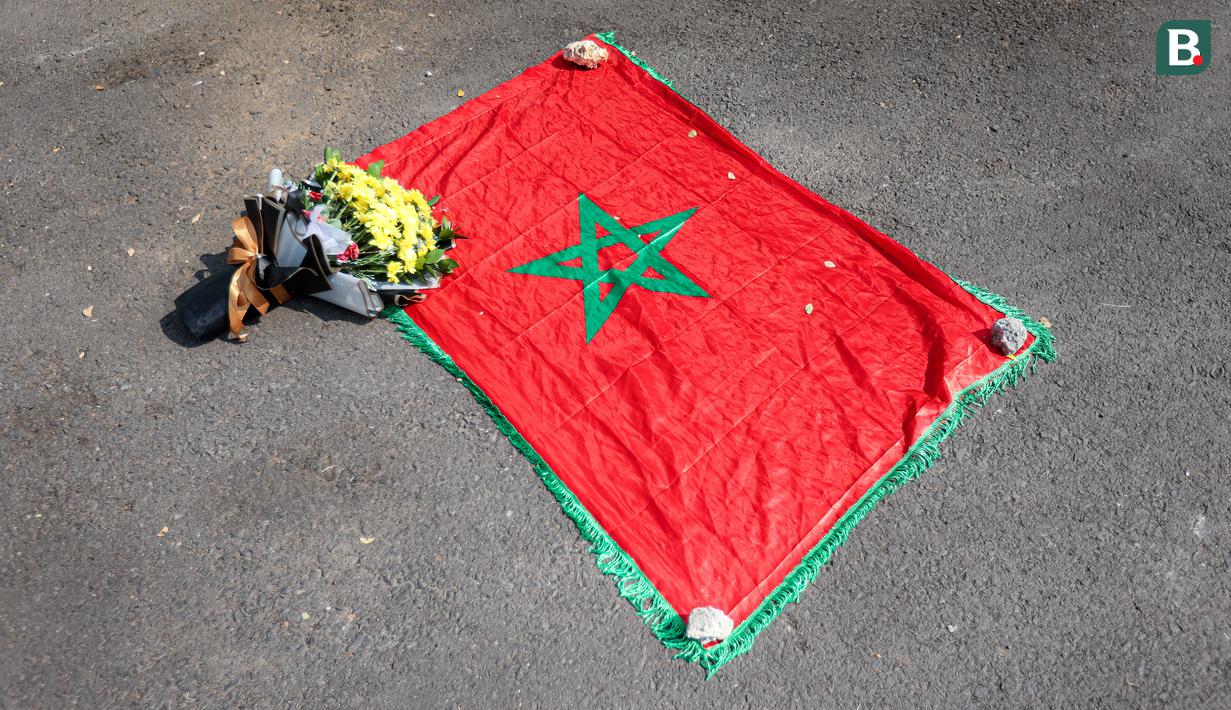 <p>Bendera Maroko dibentangkan oleh Mohammad Aziz Mrabat saat menunggu kedatangan bus Timnas Maroko U-17 menjelang laga kedua Grup A Piala Dunia U-17 2023 melawan Timnas Ekuador U-17 di Stadion Gelora Bung Tomo (GBT), Surabaya, Senin (14/11/2023). (Bola.com/Bagaskara Lazuardi)</p>