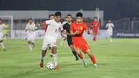 Striker Timnas Indonesia U-20, Arkhan Kaka (kiri) berebut bola dengan bek Timnas China U-20, Peng Xiao pada laga kedua uji coba internasional di Stadion Madya Gelora Bung Karno, Senayan, Jakarta, Senin (25/3/2024). (Bola.com/Abdul Aziz)
