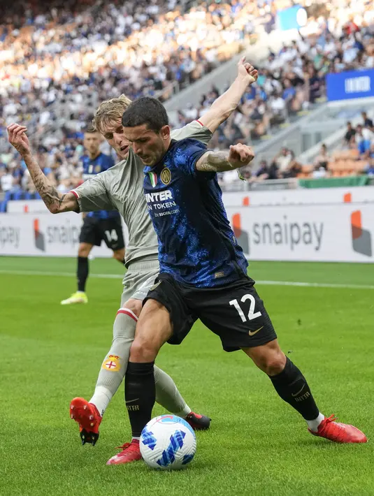 Gelandang Inter Milan, Stefano Sensi mengontrol bola dari kawalan pemain Genoa, Nicolo Rovella pada pertandingan perdana Liga Serie A Italia di stadion San Siro di Milan, Italia, Sabtu (21/8/2021). Inter Milan menang telak atas Genoa dengan skor 4-0. (AP Photo/Antonio Calanni)