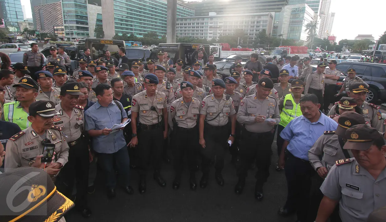 Polisi tengah melakukan apel pengamanan di Kawasan Bundaran HI, Jakarta, kamis (31/12). Polisi menerjukan 8.978 personil untuk menjaga malam pergantian tahun di Jakarta. (Liputan6.com/Angga Yuniar)
