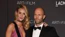 Model dan aktris Rosie Huntington -Whiteley berpose bersama sang kekasih, aktor Jason Statham saat menghadiri gala LACMA Art + Film di Los Angeles, California, Minggu (7/11). (AFP Photo/ Mark Ralston)