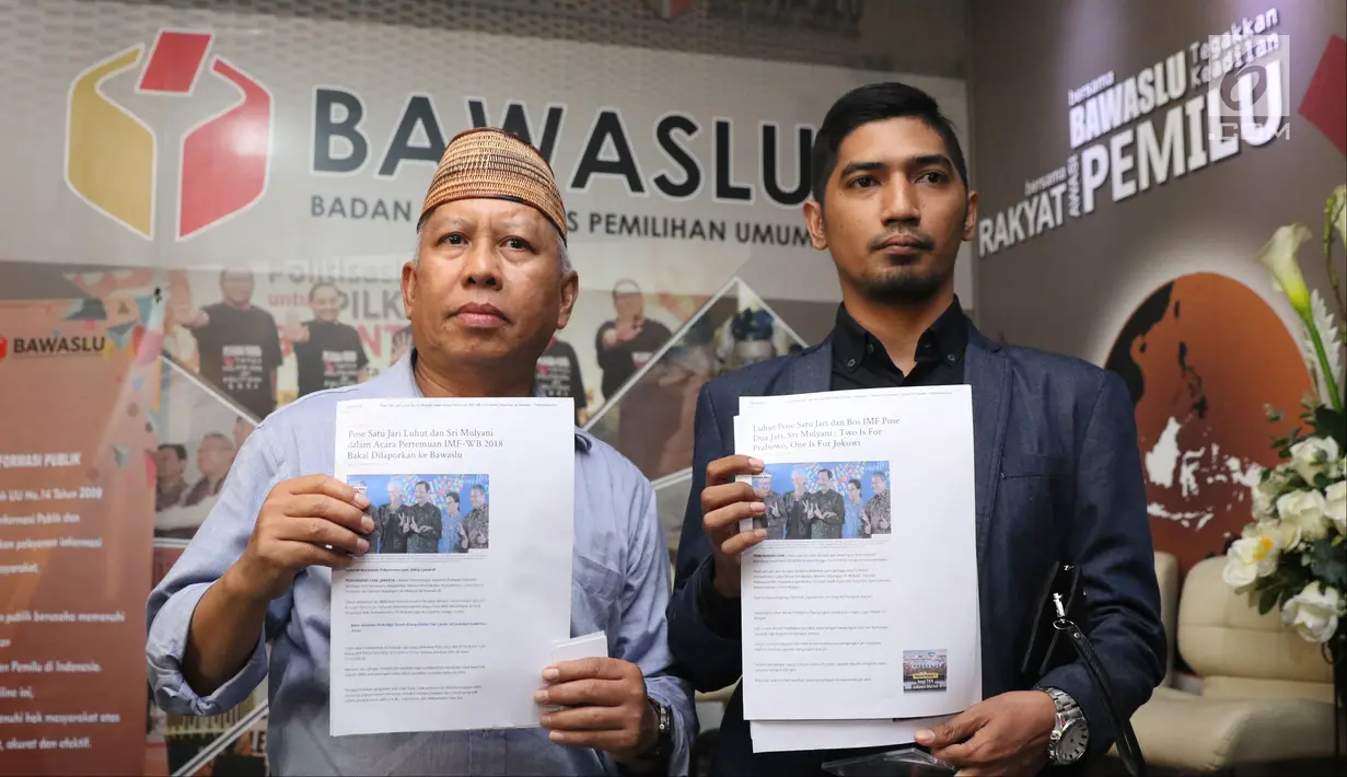 Dahlan Pido (kiri) menunjukkan bukti jelang membuat pengaduan pelanggaran Pemilu di Gedung Bawaslu, Jakarta, Kamis (18/10). Mereka melaporkan dugaan pelanggaran pemilu oleh menteri Luhut Binsar Pandjaitan dan Sri Mulyani. (Liputan6.com/Helmi Fithriansyah)