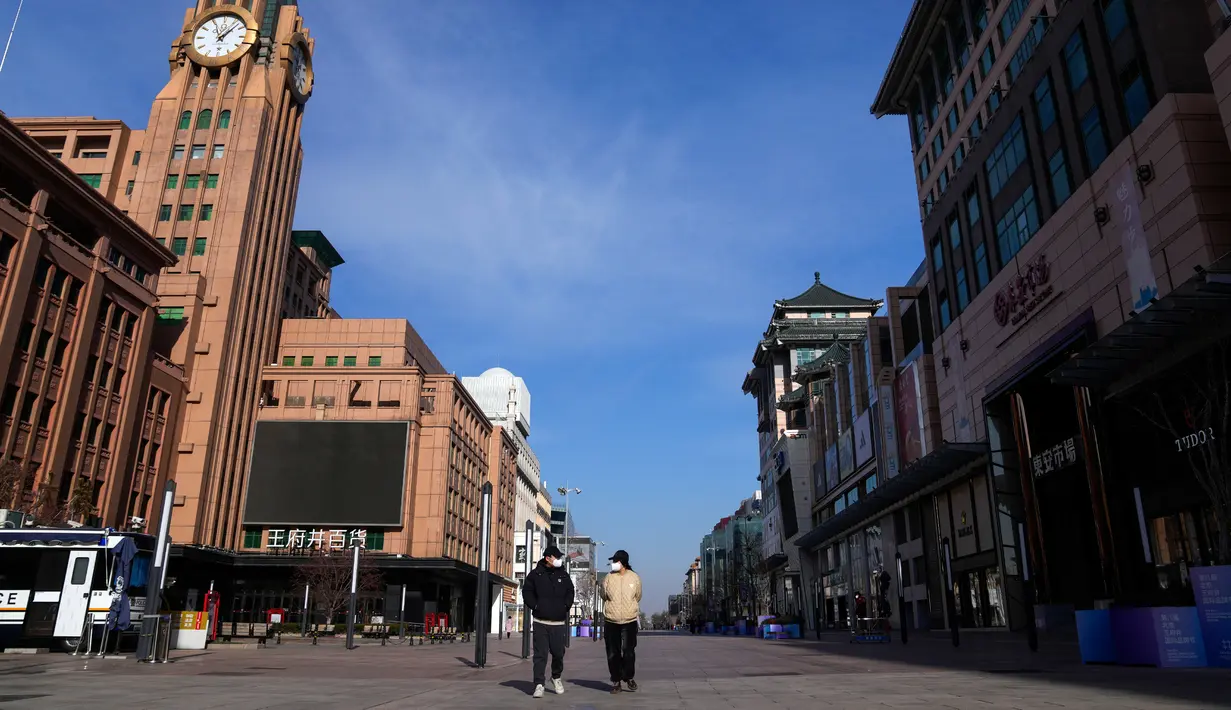 Orang-orang yang memakai masker berjalan melalui distrik perbelanjaan Wangfujing, Beijing, China, Rabu (14/12/2022). Mulai hari ini, Komisi Kesehatan Nasional China melaporkan penurunan kasus harian COVID-19 sejak pemerintah melonggarkan pengujian PCR setelah kasus harian mencapai rekor tertinggi. (AP Photo/Andy Wong)