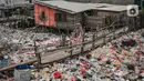 Warga berjalan di jembatan kayu di antara sampah di perkampungan nelayan Cilincing, Jakarta, Minggu (21/2/2022). Peringatan HPSN 2022, Pemprov DKI Jakarta mengajak warga Jakarta peduli sampah mulai dari lingkungan terdekat dengan cara memilah sampah dari rumah. (Liputan6.com/Faizal Fanani)