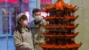 Orang-orang berhenti di salah satu toko di sebuah jalan kawasan perniagaan di Wuhan, Provinsi Hubei, China tengah, pada 30 Maret 2020. Jalan-jalan kawasan perniagaan di Wuhan kembali ramai seiring meredanya wabah COVID-19. (Xinhua/Shen Bohan)