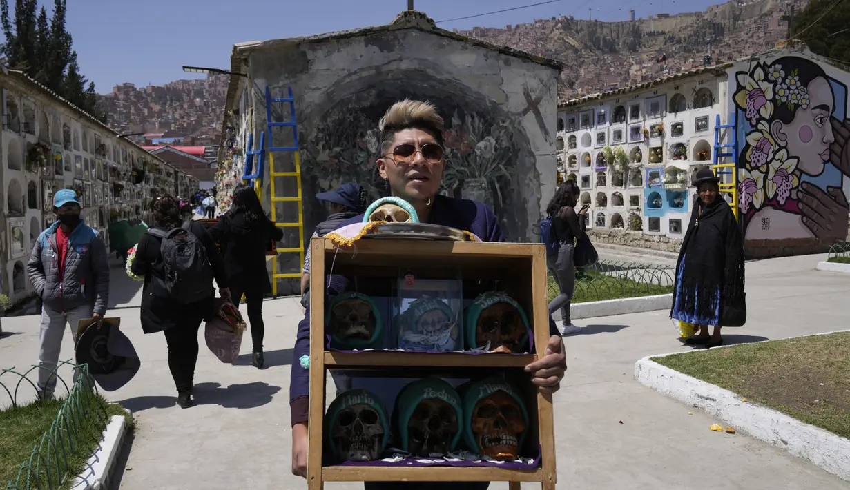Seseorang membawa sekotak tengkorak manusia yang dihias untuk diberkati oleh seorang imam selama Festival Natitas di Pemakaman Umum di La Paz, Bolivia, Selasa (8/11/2022). Tradisi tahunan ini merayakan kematian di Bolivia dengan tengkorak yang dirawat dan didekorasi oleh mereka yang menggunakannya sebagai jimat untuk perlindungan. (AP Photo/Juan Karita)