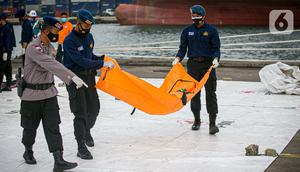 Petugas membawa body part dari kapal Basarnas di JICT II Tanjung Priok, Jakarta, Jumat (15/1/2021). Sebanyak 13 body part penumpang Sriwijaya Air SJ182 berhasil ditemukan dan nantinya akan diidentifikasi di RS Polri Keramat Jati. (Liputan.com/Faizal Fanani)