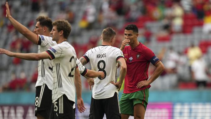 Penyerang Portugal, Cristiano Ronaldo berbicara dengan gelandang Jerman, Toni Kroos usai pertandigan grup F Euro 2020 di Allianz Arena, Munich, Sabtu (19/6/2021). Portugal takluk dari Jerman dengan skor 2-4. (AP Photo/Matthias Schrader, Pool)