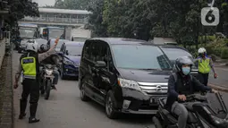 Anggota polisi melakukan penindakan kepada sebuah kendaraan saat ganjil genap di kawasan Jalan D.I Panjaitan, Jakarta, Senin (6/6/2022). Perluasan ganjil genap Jakarta tersebut dilakukan karena volume kendaraan meningkat di Ibu Kota RI tersebut ditiadakan. (Liputan6.com/Faizal Fanani)