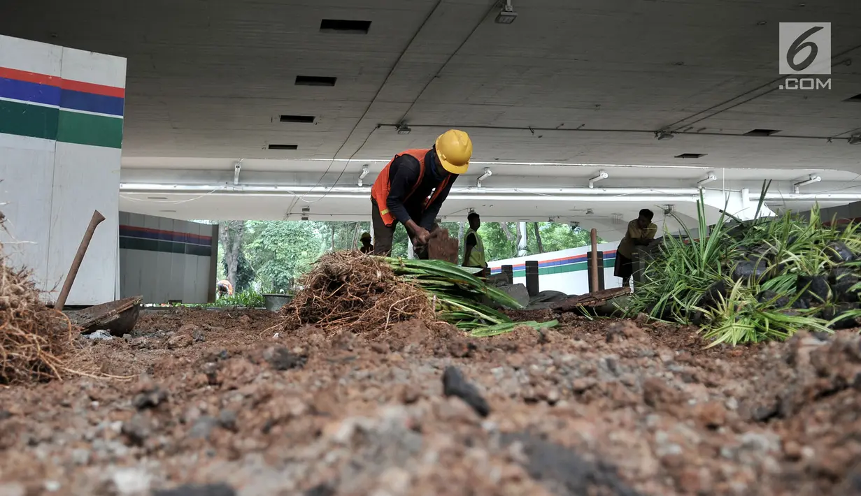 Aktivitas pekerja saat menyelesaikan pembangunan taman di kolong Jembatan Semanggi, Jakarta, Kamis (7/3). Taman kolong Jembatan Semanggi nantinya akan difungsikan sebagai pusat interaksi warga. (merdeka.com/Iqbal Nugroho)