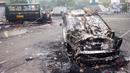 Sejumlah kendaraan dibakar di luar Stadion Kanjuruhan, Malang, Jawa Timur, Minggu (2/10/2022). Sebanyak 127 orang tewas ketika para penggemar yang marah menyerbu lapangan sepak bola setelah pertandingan antara Arema FC dan Persebaya Surabaya pada 1 Oktober 2022. (PUTRI/AFP)