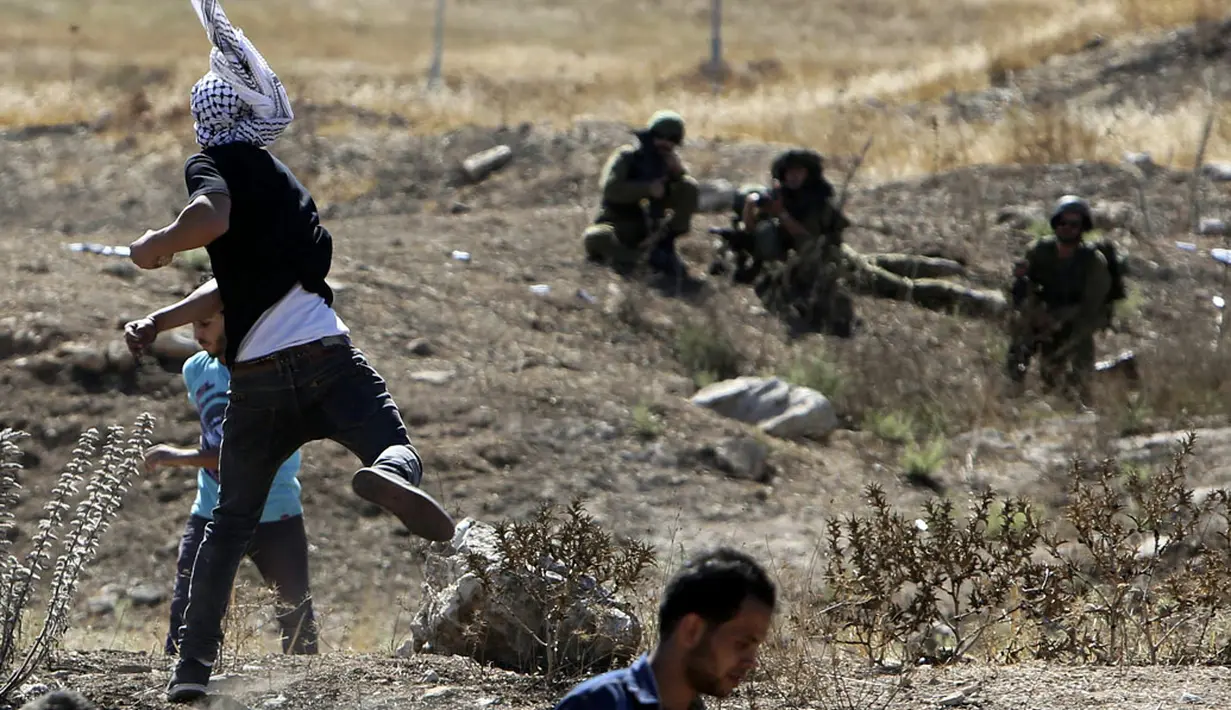 Di Hawara, warga Pelstina melempari militer Israel dengan batu saat melakukan aksi protes terhadap serangan ke jalur Gaza, (25/7/2014). (REUTERS/Abed Omar Qusini)