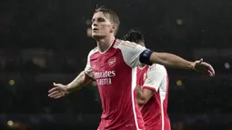 Pemain Arsenal, Martin Odegaard melakukan selebrasi setelah mencetak gol keempat timnya ke gawang PSV Eindhoven pada laga Grup B Liga Champions 2023/2024 di Emirates Stadium, London, Kamis (21/09/2023) dini hari WIB. (AP Photo/Kin Cheung)