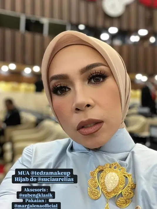 Ia melengkapi penampilannya dengan bros emas dari @subeng klasik. Serta hijab segi empat warna coklat muda yang selaras dengan bawahannya.  [@melly_goeslaw].