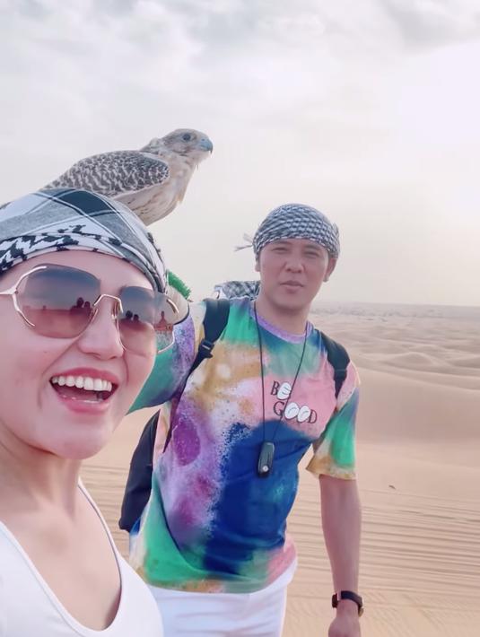 Pasutri baru Via Vallen dan Chevra Yolandi sedang bulan madu ke Dubai. Ini tampak dari video yang diunggah keduanya di akun Instagram terverifikasi masing-masing, pada Minggu (7/8/2022). Video itu merekam perjalanan mereka dari Bandara Internasional Soekarno-Hatta Banten yang terhubung ke padang pasir, di Dubai. Mereka tampak bungah, serasa dunia milik berdua. (Foto: Dok. Instagram @viavallen)