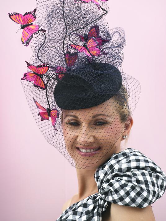 Seorang wanita mengenakan topi unik sebelum pertandingan pacuan kuda Piala Melbourne di Melbourne (5/11/2019). Para wanita tampil cantik dan modis dengan hiasan kepala yang mereka gunakan selama menyaksikan balap kuda di Melbourne Cup.  (AFP Photo/William West)