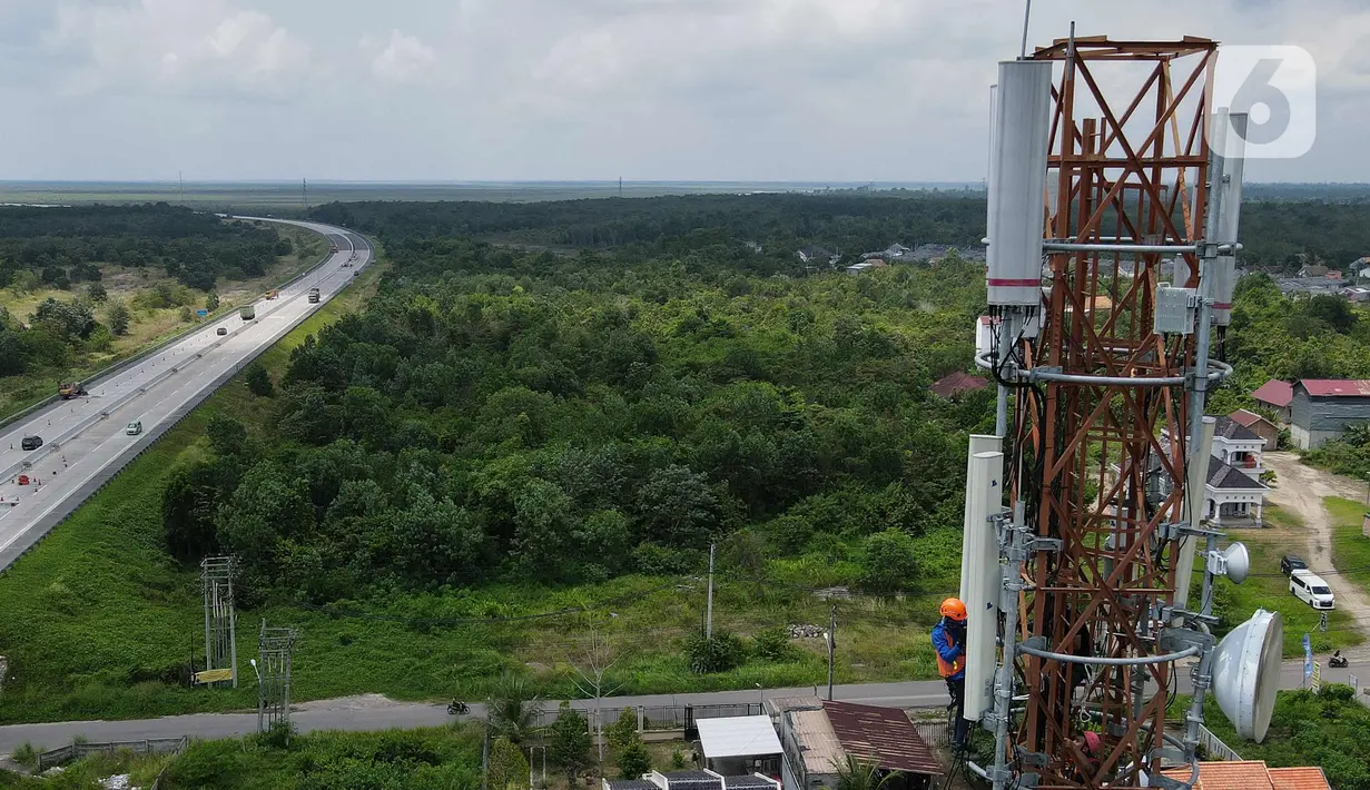 Foto udara teknisi melakukan pemeliharaan tower BTS 4G XL Axiata di Kuta Raya, Kayu Agung, Ogan Komering Ilir (OKI), Sumatera Selatan. Senin (13/3/2023). XL Axiata memastikan jaringan miliknya siap melayani kebutuhan pelanggan dan masyarakat selama Ramadhan hingga Hari Raya Idul Fitri 1444 Hijriah. (Liputan6.com/Herman Zakharia)