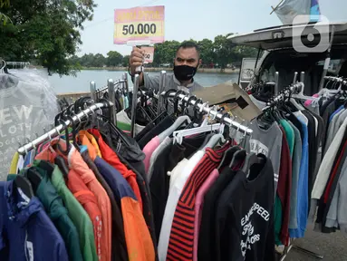 Ridwan (40) menata baju seken (baju bekas) impor di Pamulang, Tangerang Selatan, Banten, Senin (29/9/2020). Sebelumnya Ridwan merupakan pengusaha alat sewa pesta, karena kondisi pandemi Covid-19 sepi hajatan iya beralih menjual baju bekas demi memenuhi kebutuhan sehari-hari. (merdeka.com/Dwi Narwoko