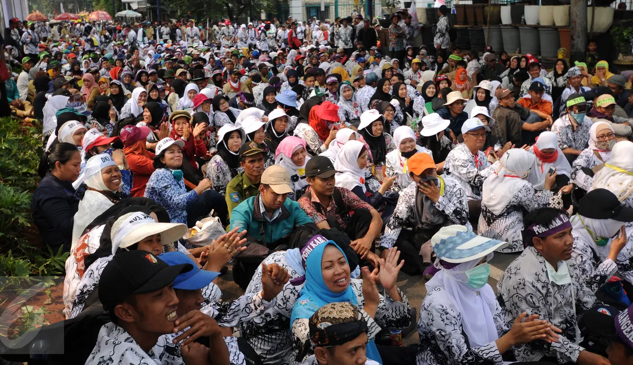Ribuan guru honorer dari berbagai wilayah duduk di ruas jalan Asia Afrika Jakarta, Selasa (15/9/2015). Sebagian ruas jalan Asia Afrika ditutup sementara saat para guru honorer melakukan aksi (Liputan6.com/Helmi Fithriansyah)