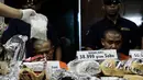 Petugas memperlihatkan barang bukti saat rilis sindikat peredaran narkotika di Gedung BNN, Jakarta, Jumat (28/10). Sebanyak 50.000 butir H5, 39 kg sabu dan 98.960 butir ekstasi berhasil diamankan dari tiga tersangka. (Liputan6.com/Yoppy Renato)