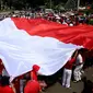 Bendera merah putih yang terbentang saat Parade Bhineka Tunggal Ika di kawasan Patung Kuda, Jalan MH Thamrin, Jakarta Pusat, Sabtu (19/11). (Liputan6.com/Gempur M. Surya)