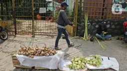 Pedagang menjajakan kulit ketupat dan ketupat siap hidang di kawasan Cibubur, Jakarta, Rabu (30/7/2020). Pedagang musiman menjelang Idul Adha tersebut menjual kulit ketupat dengan harga Rp 10 ribu, sedangkan ketupat yang siap untuk dihidangkan seharga Rp 30 ribu. (Liputan6.com/Herman Zakharia)