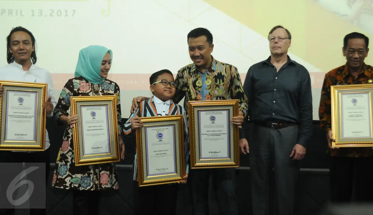Jefri Setiawan (ketiga kiri) usai menerima penghargaan dari Official World Record di Auditorium Kemenpora, Jakarta, Kamis (14/11). Jefri mencatat rekor dunia memainkan 60 lagu menggunakan keyboard dengan mata tertutup. (Liputan6.com/Helmi Fithriansyah)