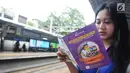 Seorang penumpang membawa brosur lawan pelecehan dalam rangka memperingati Hari Perempuan Internasional di Stasiun Sudirman, Jakarta, Selasa (12/3). (Liputan6.com/Herman Zakharia)