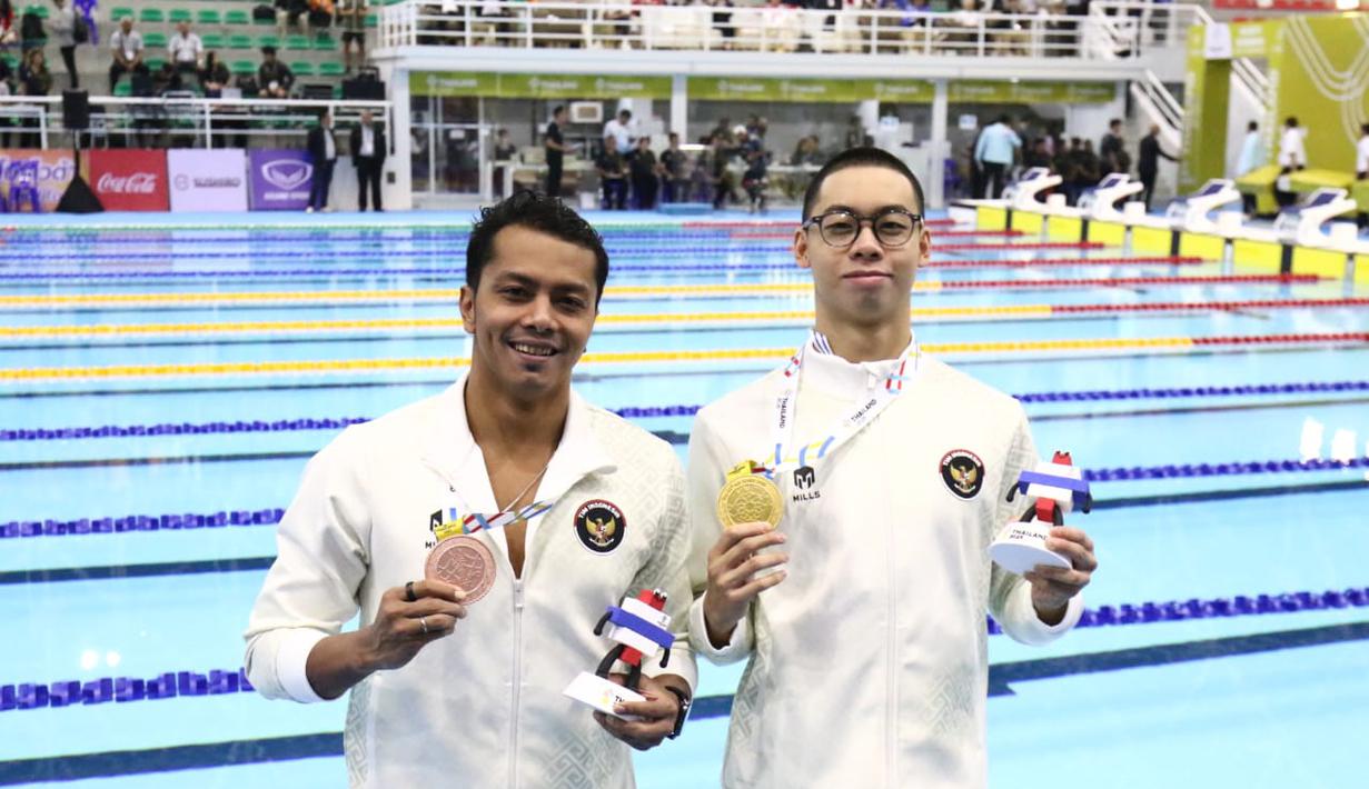 Jason Donovan Yusuf (kanan) dan Siman Sudartawa (kiri) memamerkan medali emas dan perunggu nomor 50 meter gaya punggung putra pada SEA Games 2025 yang bertempat di Swimming Pool, Sports Authority of Thailand, Bangkok, Kamis (11/12/2025) sore WIB. (Dok. Akuatik Indonesia)