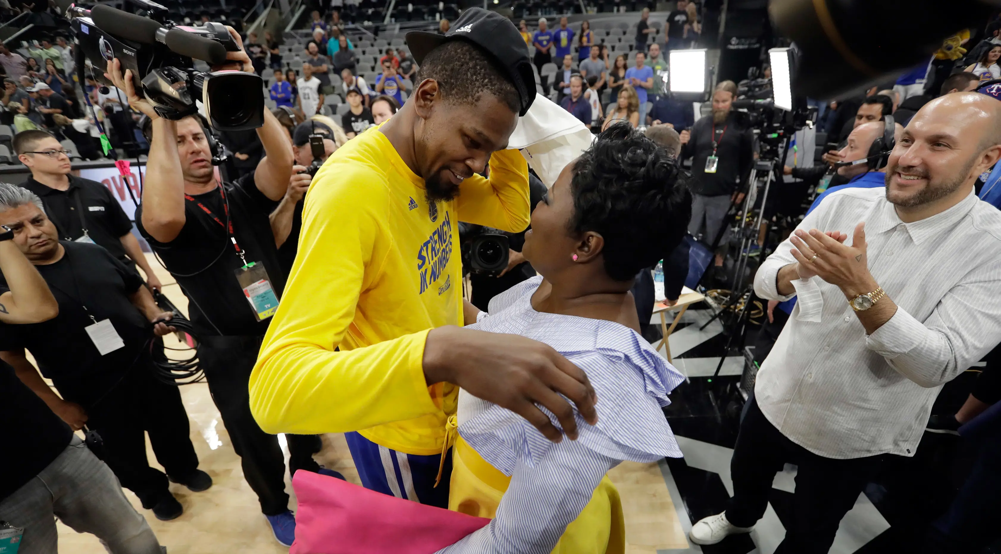 Kevin Durant mendapat pelukan dari sang ibu, Wanda Pratt, usai kemenangan Golden State Warriors atas San Antonio Spurs pada final Wilayah Barat. Warriors menang 4-0 dan tidak terkalahkan di playoffs. (AP Photo/Eric Gay)