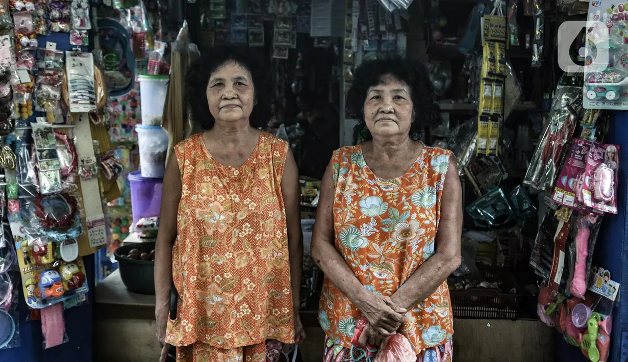Warga kembar Una dan Uni saat berbelanja di salah satu warung di Kampung Tehyan, Tangerang, Banten, Selasa (9/2/2021). Kampung yang lebih dikenal dengan perkampungan Cina Benteng ini salah satu bukti sejarah lahirnya masyarakat hasil perpaduan Tionghoa dan pribumi. (merdeka.com/Iqbal S. Nugroho)