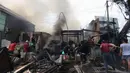 Warga membantu petugas pemadam kebakaran melakukan pendinginan rumah dan kios yang terbakar di Jalan Minangkabau, Jakarta, Selasa (7/7/2020). Delapan unit mobil pemadam kebakaran dikerahkan untuk memadamkan api yang hingga saat ini belum diketahui penyebab kebakaran. (merdeka.com/Imam Buhori)