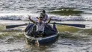 Seorang nelayan Palestina yang mengenakan masker karena pandemi virus corona COVID-19 menunjukkan isyarat kemenangan saat menangkap ikan di Laut Mediterania, Rafah, Jalur Gaza, Rabu (2/9/2020). (SAID KHATIB/AFP)