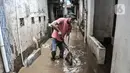 Warga membersihkan lumpur dan sampah saat banjir di permukiman Kebon Pala, Jatinegara, Jakarta, Minggu (25/10/2020). Hampir 12 jam banjir kiriman dari Bogor itu masih merendam permukiman warga di RT 11 RW 05 Kebon Pala dengan ketinggian mencapai pinggang orang dewasa.  (merdeka.com/Iqbal Nugroho)