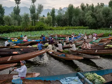 Para pria Kashmir menjual produk mereka di pasar sayur terapung di Danau Dal di Srinagar, Kashmir yang dikuasai India pada 26 Juli 2020. Sayuran yang diperdagangkan di pasar terapung ini disuplai ke Srinagar dan banyak kota di lembah Kashmir. (AP Photo/Dar Yasin)