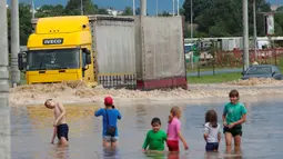 Sebuah truk melintas di jalan banjir di Minsk, Belarus, Rabu (13/7). (REUTERS / Vasily Fedosenko)